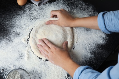 Woman kneading dough for pastry on table