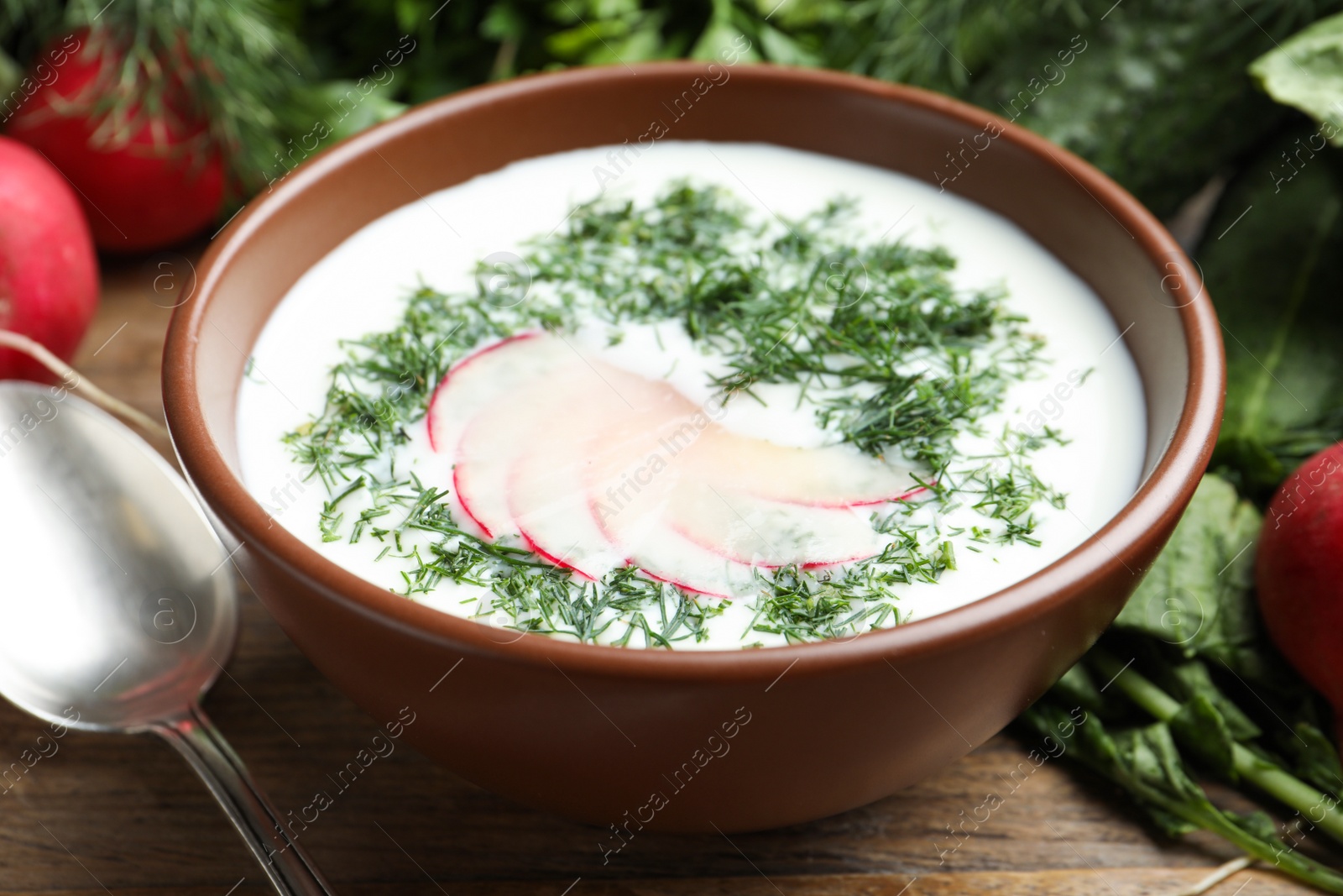 Photo of Delicious cold summer soup with kefir served on wooden table