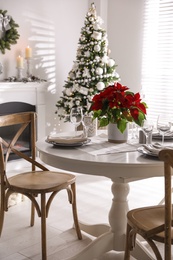 Photo of Festive table setting and beautiful Christmas decor in living room. Interior design