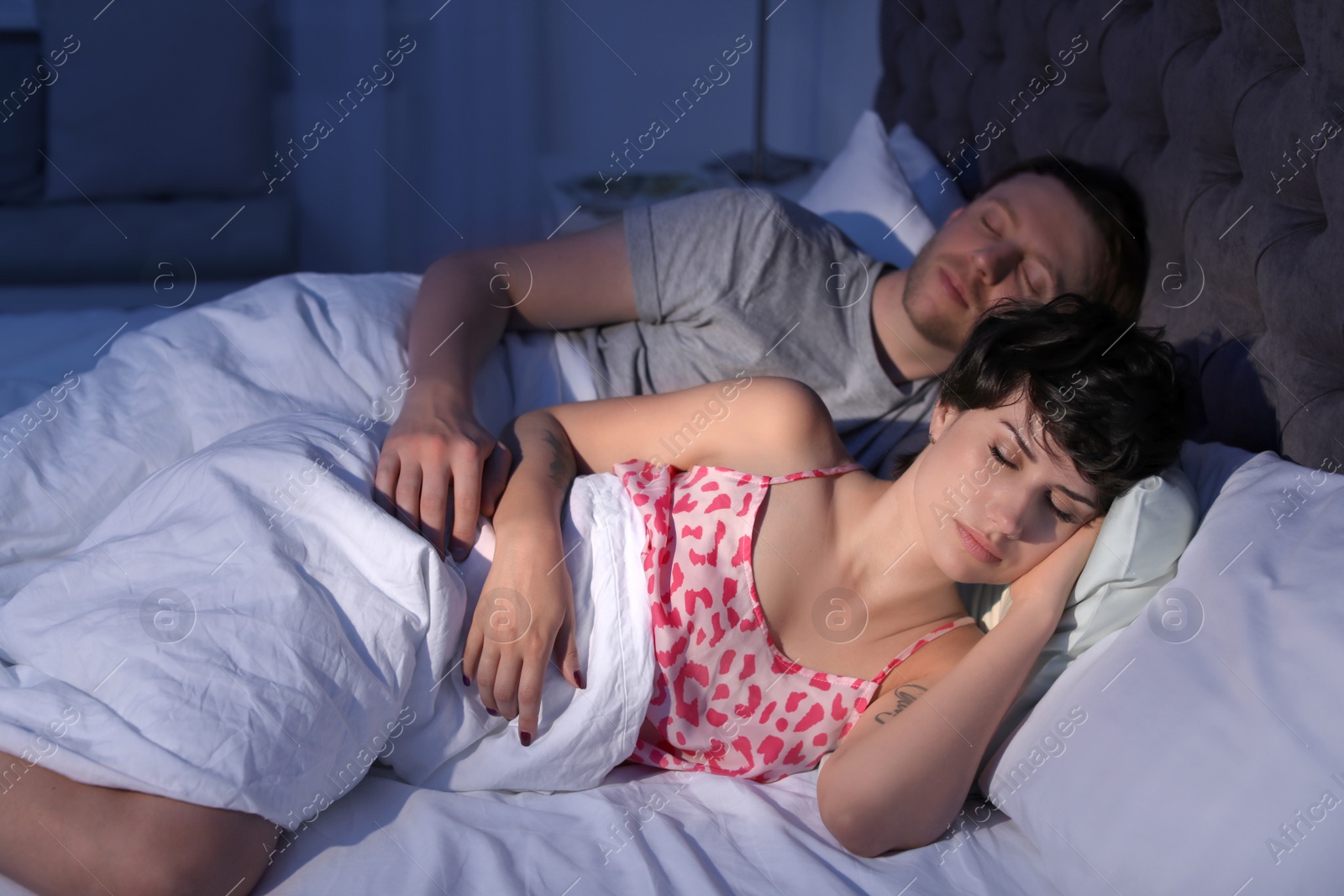 Photo of Young lovely couple sleeping in bed at home