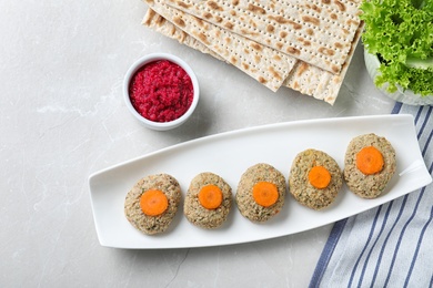 Flat lay composition with plate of traditional Passover (Pesach) gefilte fish on light background