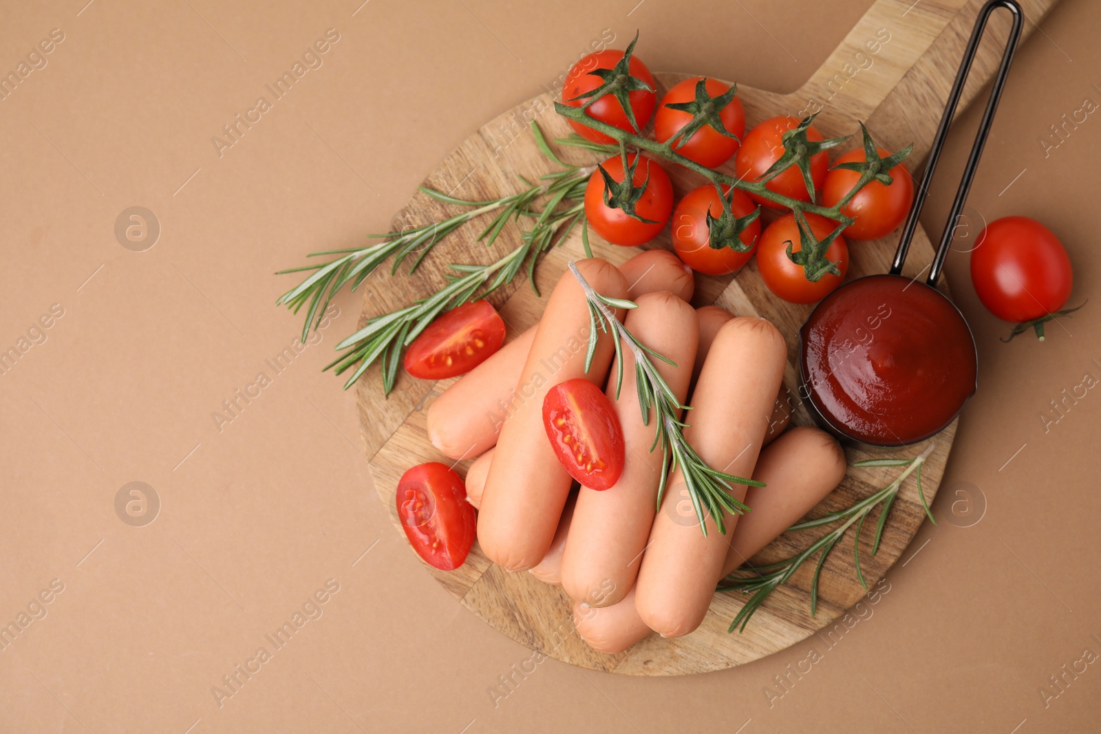 Photo of Delicious boiled sausages, tomato sauce, tomatoes and rosemary on beige table, top view. Space for text