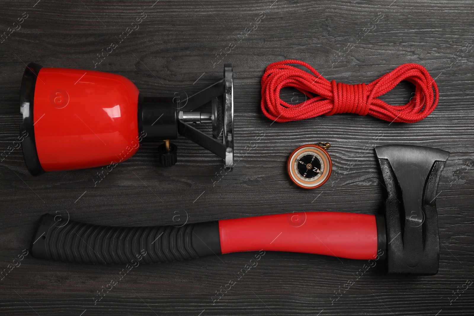 Photo of Flat lay composition with different camping equipment on dark wooden background. Traveler set