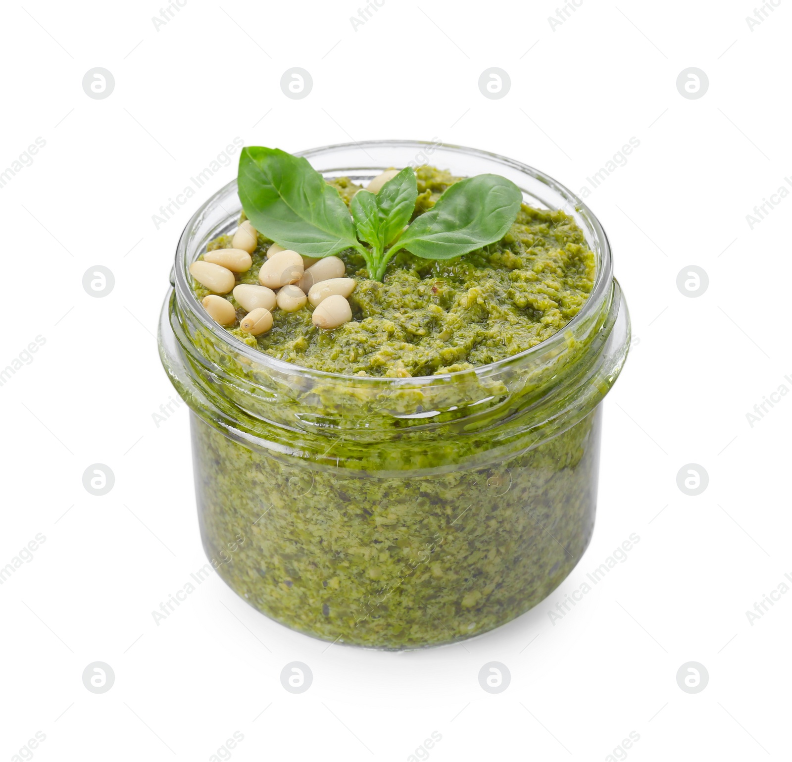 Photo of Jar with delicious pesto sauce, pine nuts and basil leaves isolated on white