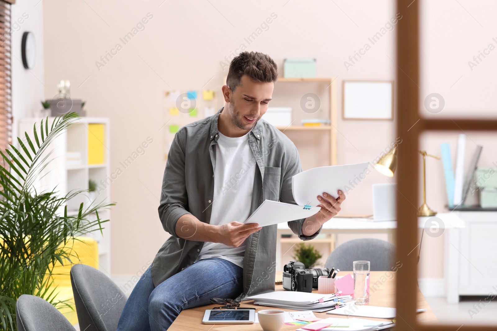 Photo of Journalist with papers at workplace in office