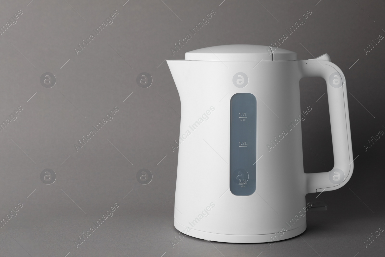 Photo of New modern electric kettle on grey background, space for text