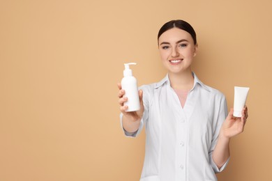 Cosmetologist with cosmetic products on beige background, space for text