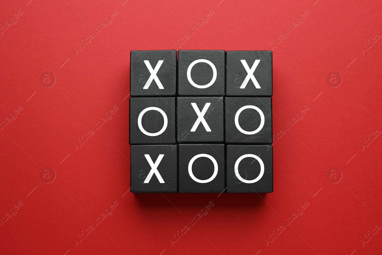 Photo of Tic tac toe cube set on red background, flat lay