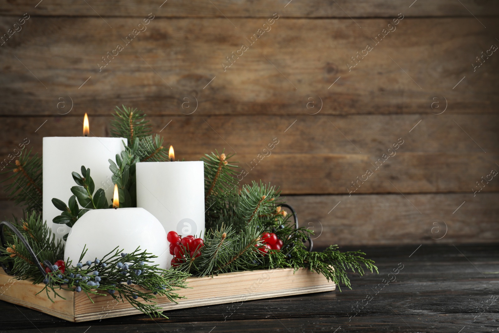 Photo of Beautiful Christmas composition with burning white candles on wooden background. Space for text