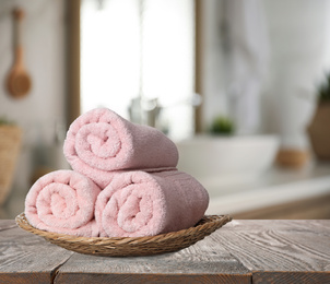 Fresh towels on wooden table in bathroom