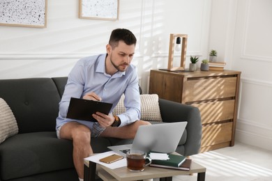 Photo of Businessman wearing shirt and underwear during video call at home