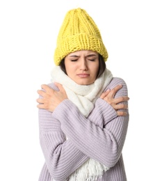 Young woman in warm clothes suffering from cold on white background