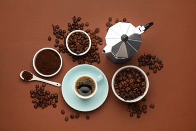 Photo of Flat lay composition with ground coffee and roasted beans on brown background