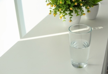 Photo of Glass of water on table indoors. Space for text