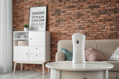 Photo of Automatic air freshener on table at home