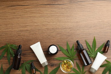 Photo of Composition with CBD oil, THC tincture and hemp leaves on wooden table, flat lay. Space for text