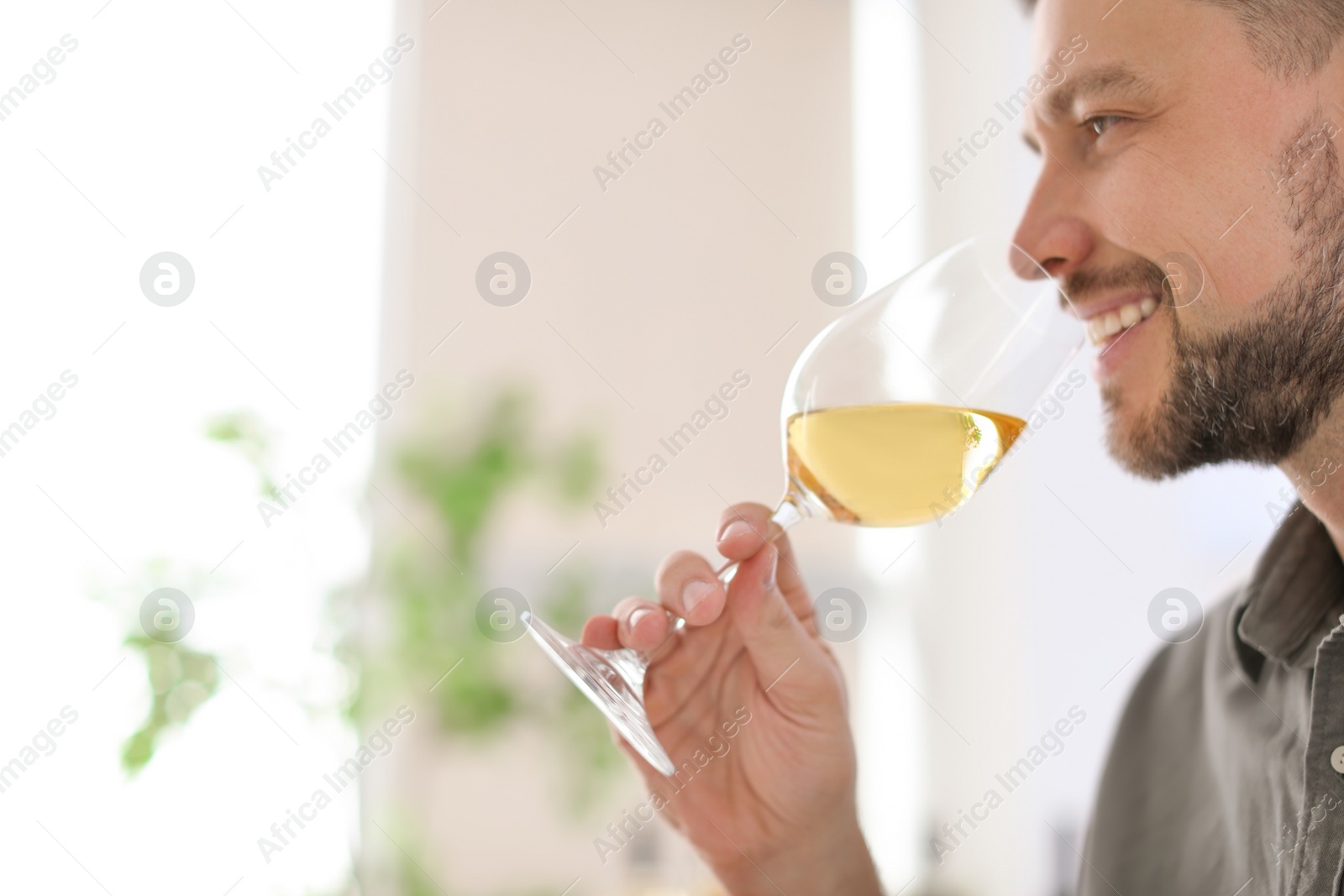 Photo of Young man with glass of wine indoors