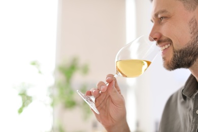 Photo of Young man with glass of wine indoors