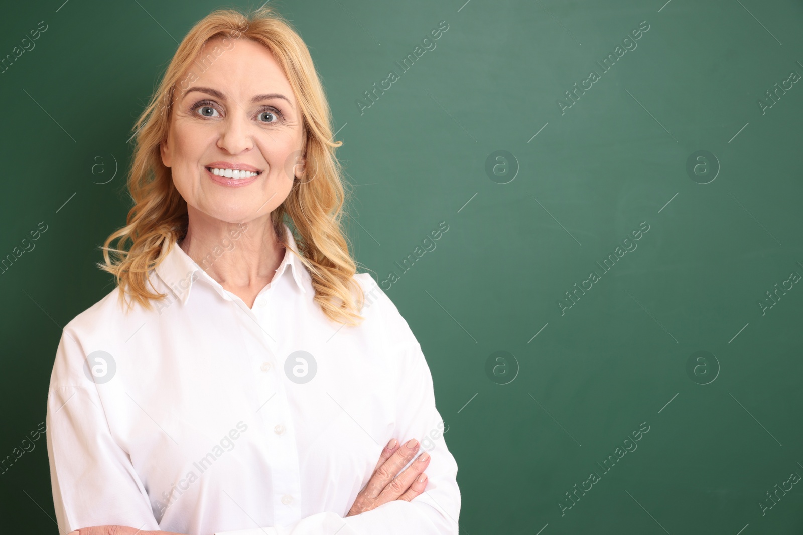 Photo of Happy professor near empty green board, space for text