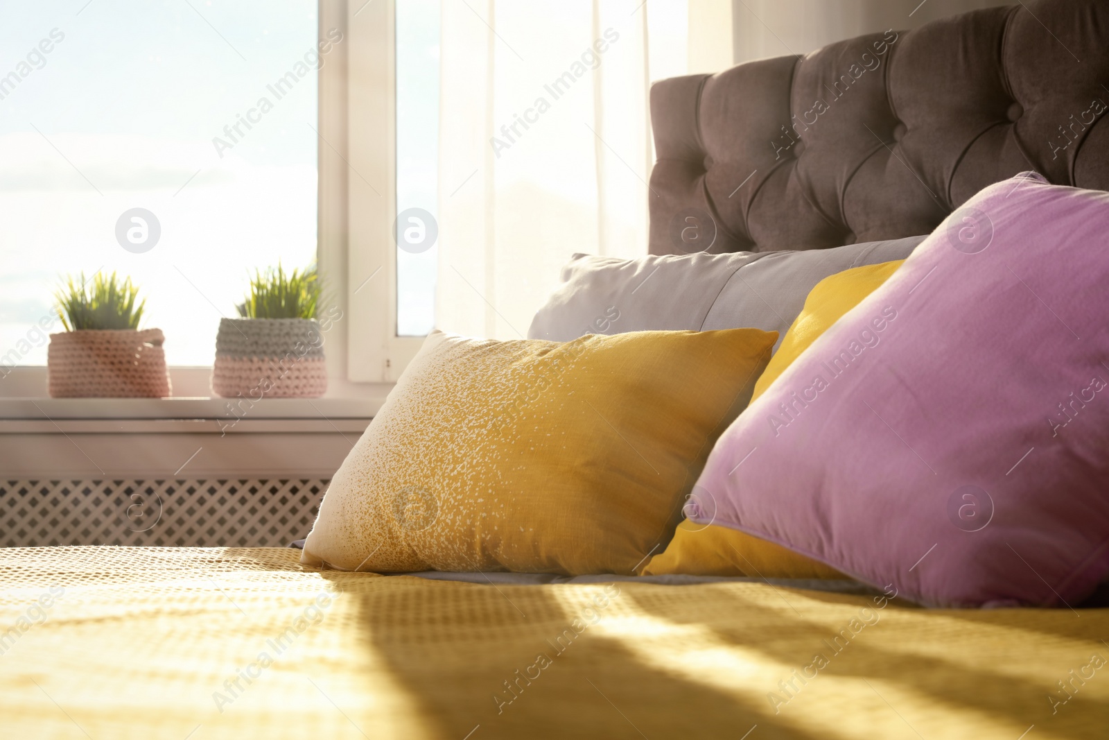 Photo of Different pillows on bed in room. Idea for interior decor