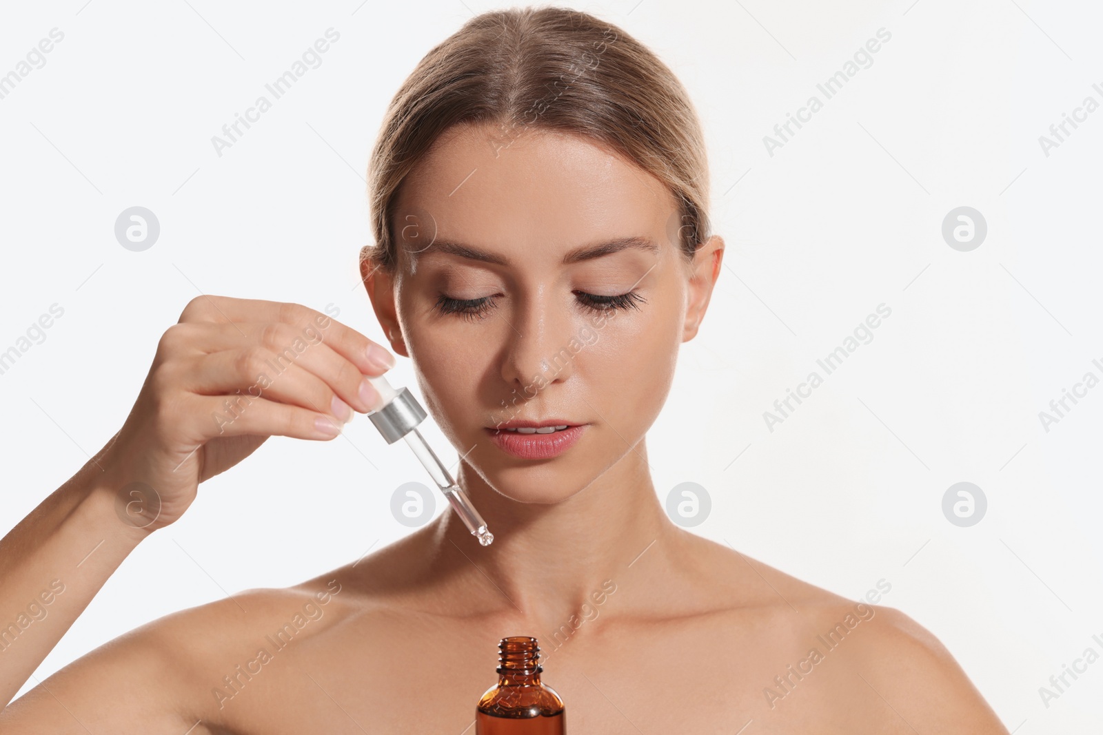 Photo of Beautiful woman with cosmetic serum on white background