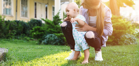 Image of Teen nanny with cute baby on green grass outdoors, space for text. Banner design 