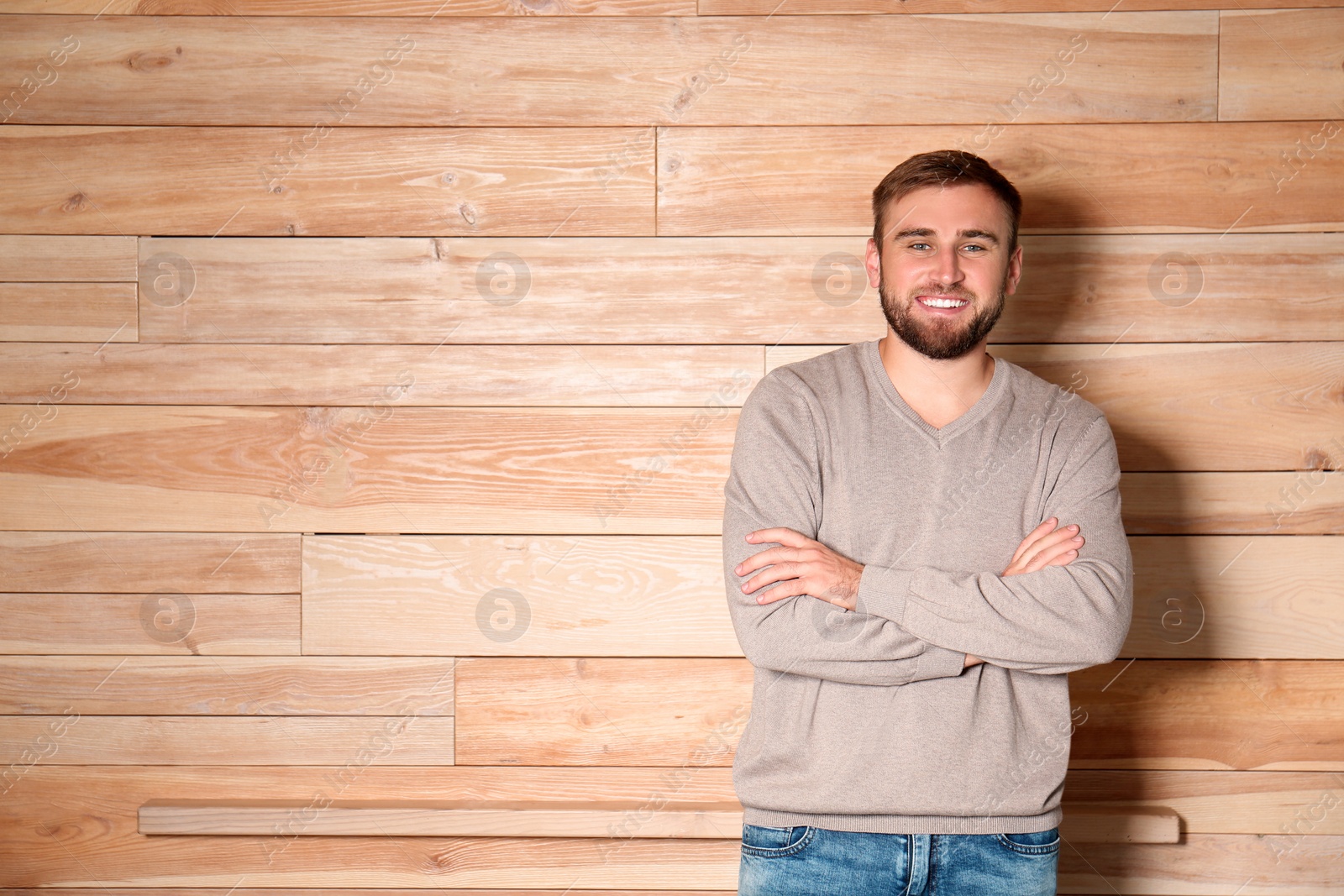 Image of Handsome man wearing warm sweater on wooden background. Space for text