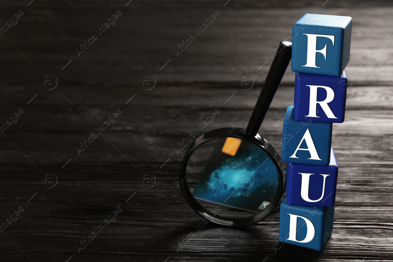 Photo of Cubes with word Fraud, credit card and magnifying glass on black wooden background. Space for text