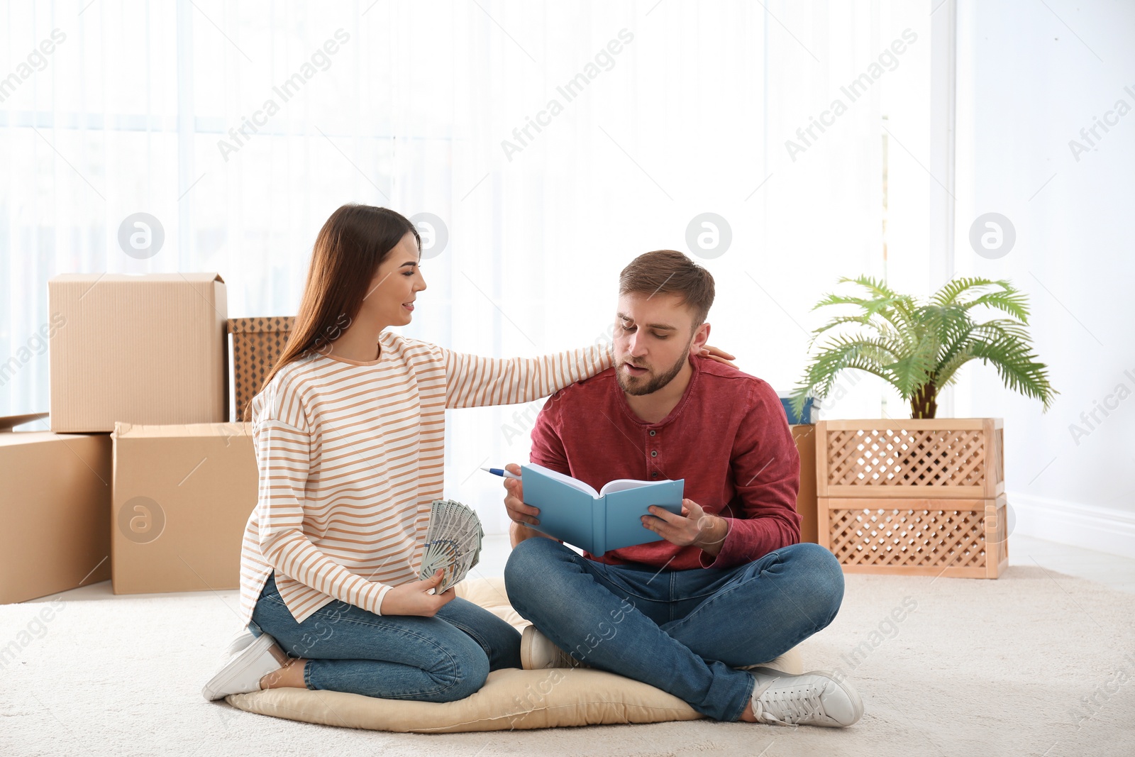 Photo of Beautiful young couple with money at home