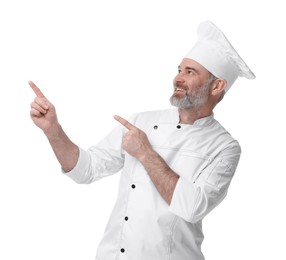 Photo of Happy chef in uniform pointing at something on white background