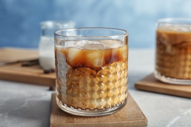 Glass with cold brew coffee and milk on table