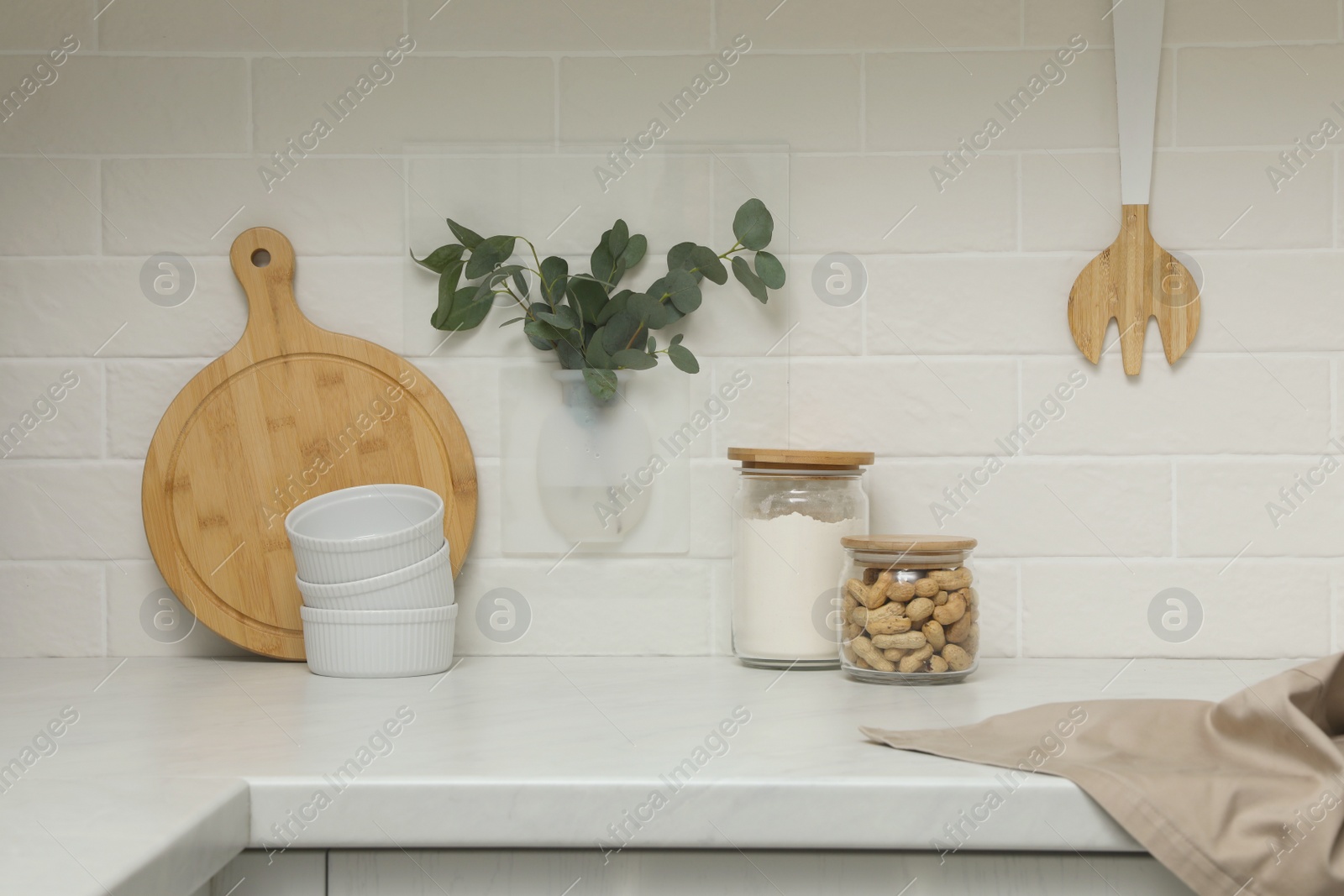 Photo of Silicone vase with eucalyptus branches on wall over countertop in kitchen