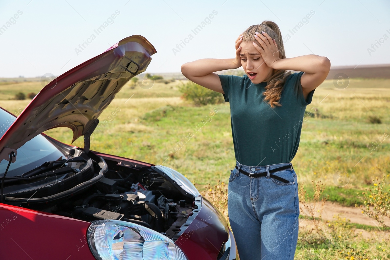 Photo of Woman near broken car on country road