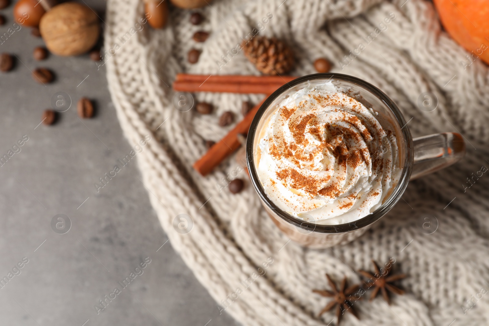 Photo of Flat lay composition with glass cup of tasty pumpkin spice latte and space for text on gray background