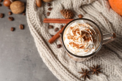 Flat lay composition with glass cup of tasty pumpkin spice latte and space for text on gray background