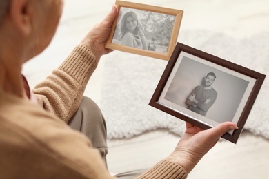 Photo of Elderly woman with framed photos at home