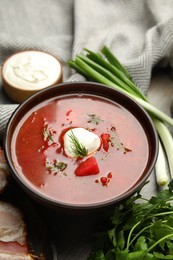 Photo of Clay bowl with Ukrainian borsch served on table