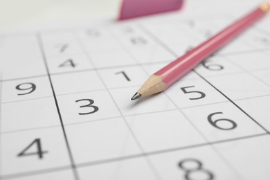 Photo of Sudoku puzzle grid and pencil, closeup view