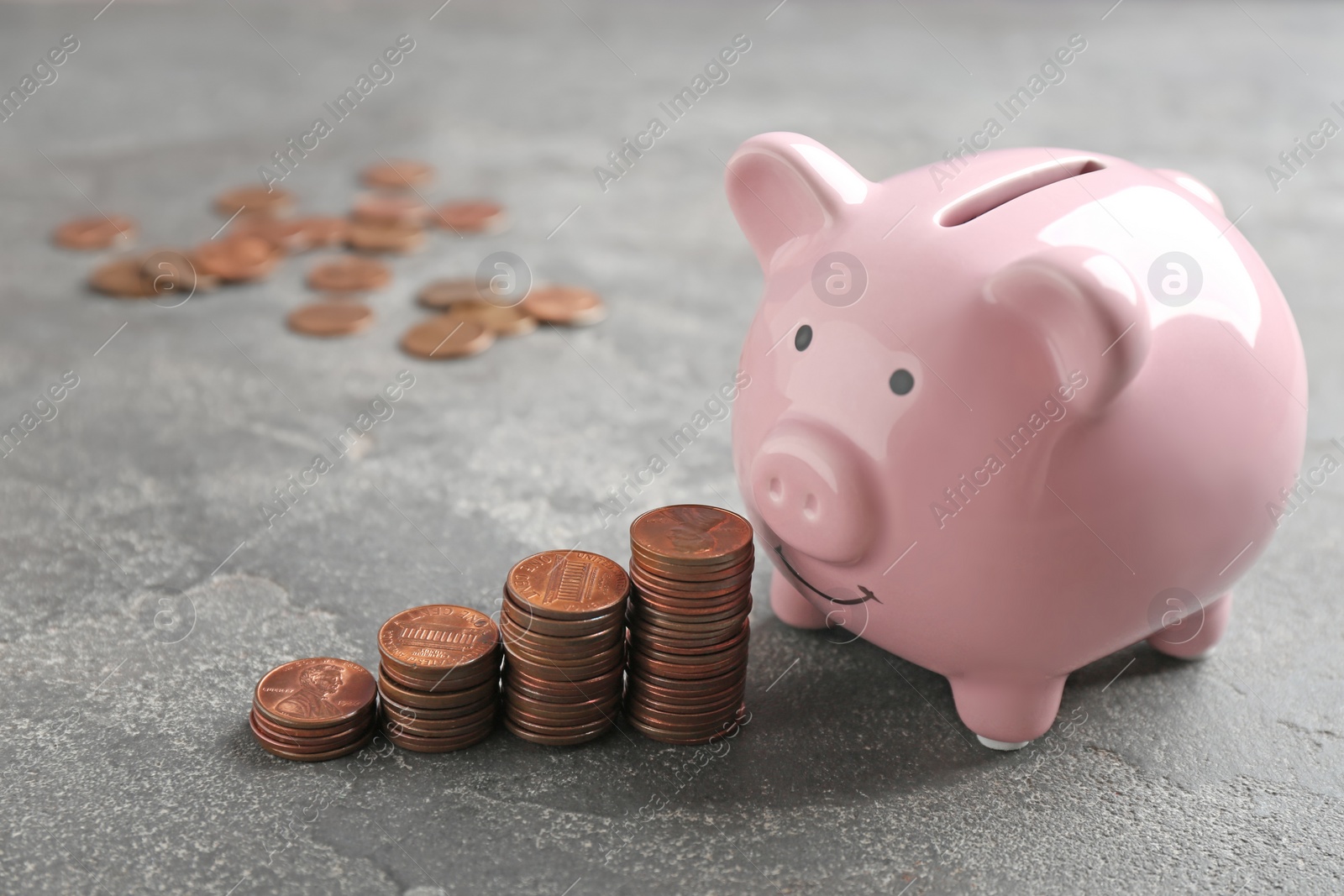 Photo of Piggy bank and coins on grey background. Space for text