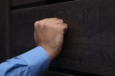 Photo of Collection agent knocking on wooden door, closeup