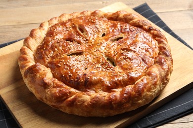 Photo of Tasty homemade pie with filling on wooden table