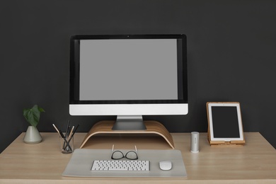 Photo of Modern workplace interior with computer on table. Space for text