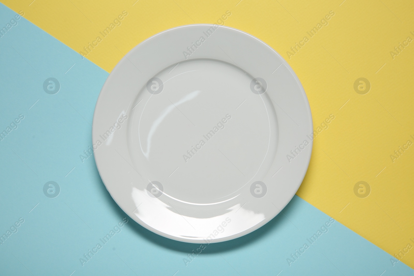 Photo of One ceramic plate on color background, top view