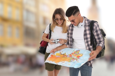 Image of Couple of travelers with map in foreign city. Summer vacation trip