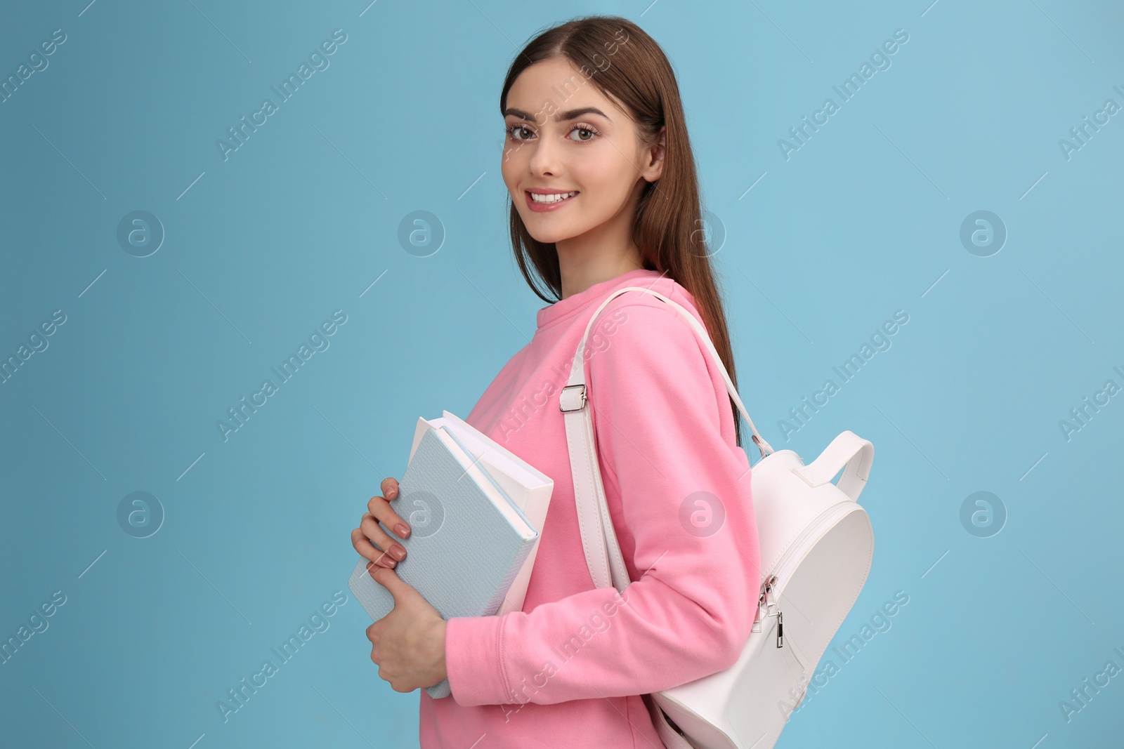 Photo of Teenage student with books and backpack on turquoise background