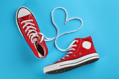 Photo of Pair of trendy sneakers on light blue background, flat lay