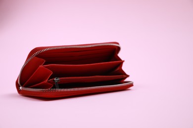 Open stylish red leather purse on pink background, space for text