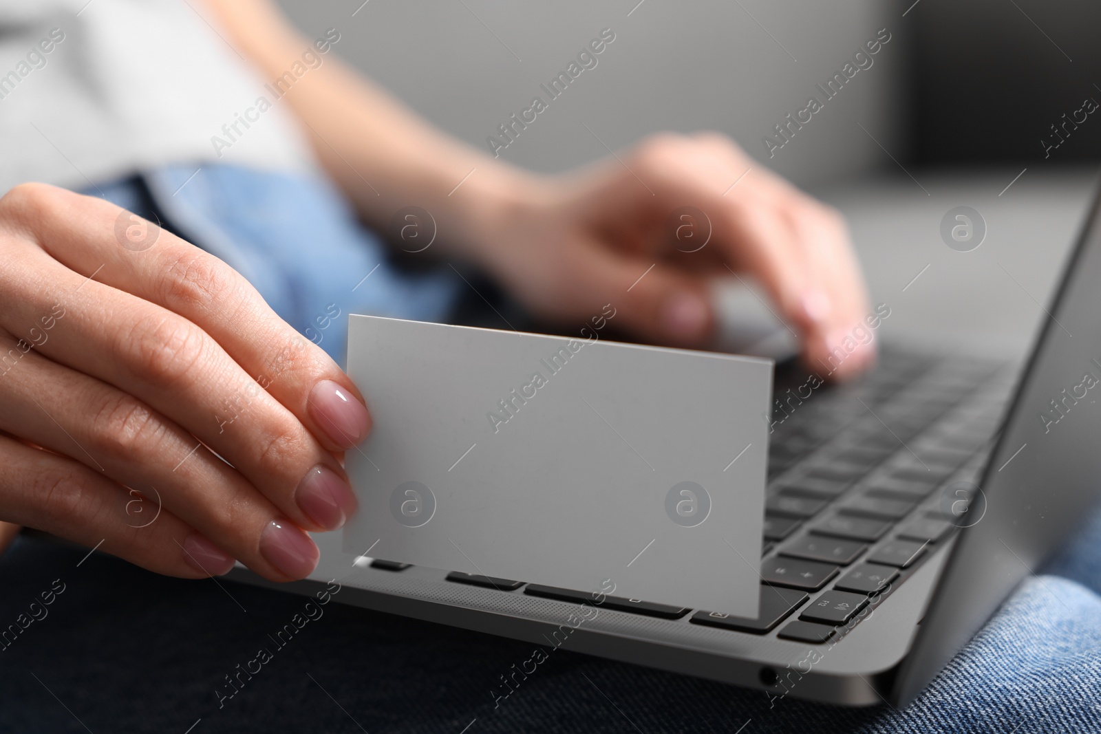 Photo of Woman with laptop holding blank business card, closeup. Space for text