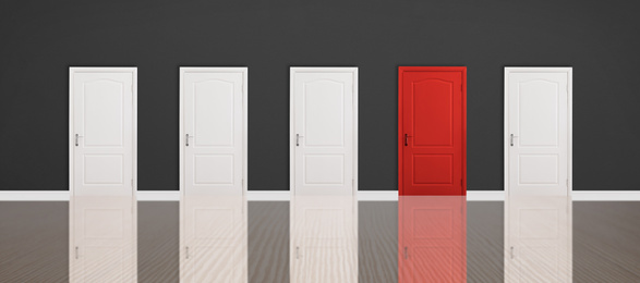 Red door among white ones in room. Concept of choice