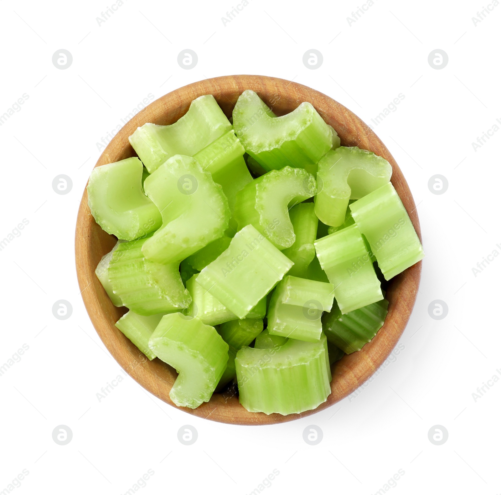 Photo of Wooden bowl of fresh cut celery isolated on white, top view
